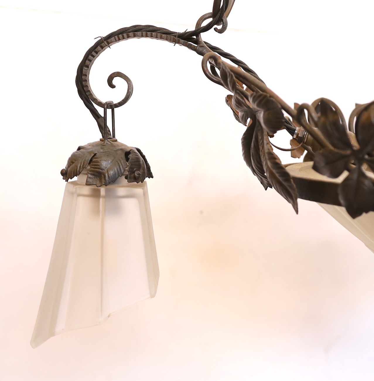 A 1930s French wrought iron and frosted glass light fitting, signed Genet & Michon, height 105cm. width 62cm
